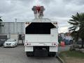 A 2021 Freightliner M2 106 bucket truck with a raised aerial lift on the back and a white body