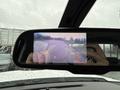 A rearview mirror displaying a backup camera view with colored guidelines indicating distance while reversing a 2015 GMC Sierra 1500
