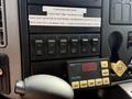 Dashboard controls of a 2011 International 4300 featuring various buttons and a digital display for vehicle settings and functions