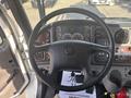 Steering wheel of a 2022 Freightliner M2 106 with various instrument gauges and controls visible on the dashboard
