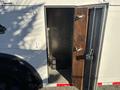 A 2006 Freightliner M2 106 truck with an open side door revealing a clean, metal storage compartment inside