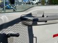 Interior door handle of a 2004 Ford F-750 with a textured gray surface and a round black knob