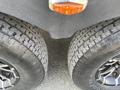 Two large, rugged tires with a distinctive tread pattern are positioned closely together showcasing their black rubber and silver rims