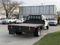 A white 2020 Ford F-550 with a flatbed in the foreground