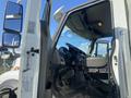 Interior view of a 2014 International 7400 truck showing the driver's seat dashboard and controls with an open door