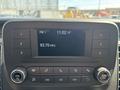 Dashboard display of a 2025 Ford Transit T-350 showing radio station and time with buttons for volume and tuning
