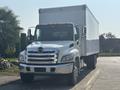A 2012 Hino 338 box truck with a white exterior and chrome accents is parked in the foreground