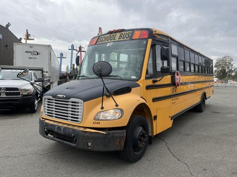 A yellow 2007 Freightliner B2 school bus with large windows and a stop sign on the side is parked, displaying the number 4340 on the front