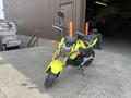 A bright yellow 2018 Honda Grom motorcycle with a sleek design and prominent headlight parked on an outdoor surface
