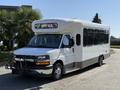 A 2020 Chevrolet Express bus with a white exterior, large windows, and a front display showing "SAFE BUS"