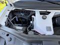 The image shows the engine compartment of a 2024 Chevrolet Express featuring a battery coolant reservoir and various engine components