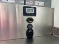Control panel featuring a digital screen and multiple switches on a stainless steel surface
