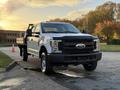 A 2018 Ford F-350 SD with a flatbed design parked in an outdoor setting showcasing its front view and robust build