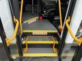 A set of steps leading into a 2020 Chevrolet Express with yellow handrails and signs indicating to watch your step