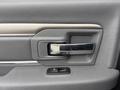 The interior door handle of a 2018 RAM 1500 featuring a chrome lever and power window control in a textured gray panel