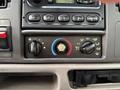The interior control panel of a 2000 Ford F-450 featuring knobs for air conditioning settings and temperature adjustment