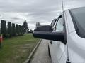 A white 2016 RAM 1500 pickup truck showing the side mirror and a portion of the door
