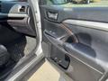 2018 Toyota Highlander interior door panel with controls and handle close-up showing a sleek design in black and brown materials
