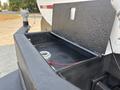 A close-up view of the rear compartment of a 2016 Freightliner M2 106 revealing a rectangular black container with a bolt and red wire inside
