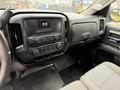 The interior of a 2016 GMC Sierra 1500 featuring a dashboard with controls and a touchscreen display alongside a gray fabric seat