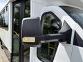 A 2017 Chevrolet Express van's side mirror is shown up close highlighting its black and silver design with some wear visible on the mirror surface
