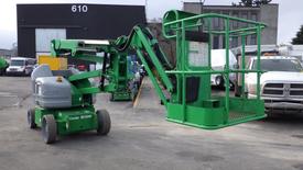 A green 2016 Genie Z-40/23N boom lift with a platform at the end and four wheels positioned on a construction site