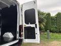 A 2020 Ford Transit 250 with its rear doors open showcasing the interior cargo space