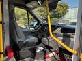 Interior view of a 2018 Ford Transit-350 showing the driver's seat dashboard and steering wheel along with a fire extinguisher in the lower left corner