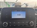 A digital display in a 2021 Ford Transit-350 showing the date 15-10-2026 the time 9:59 and various control buttons for audio and settings