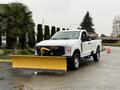 A 2023 Ford F-250 pickup truck equipped with a yellow snow plow attached to the front