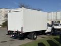 A white 2010 Ford F-450 box truck with a large empty cargo area and a black rear bumper parked at an angle