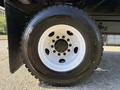 Close-up of a large black tire mounted on a white wheel belonging to a 2017 Ford F-650 Super Duty