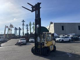 A yellow 1993 Hyster H80XL forklift with a tall mast and extended forks is parked in a busy loading area