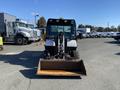 A 2015 Bobcat 5600 compact utility vehicle with a front loader attachment facing forward and large tires