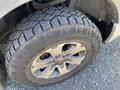 Close-up of a rugged tire on a 2014 Ford F-150 showcasing a deep tread pattern and alloy wheel design