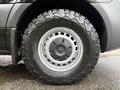 A close-up of a 2022 Mercedes-Benz Sprinter wheel featuring a grey steel rim and a rugged all-terrain tire with deep treads