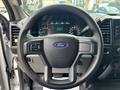 Steering wheel of a 2020 Ford F-150 with an emblem in the center and control buttons on the left side