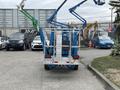 A 2016 Genie TZ-34/20 articulated boom lift with a blue frame and white platform positioned in a parking lot