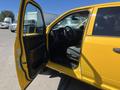 A yellow 2015 RAM 1500 with its driver's side door open showcasing the interior and steering wheel