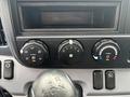 Dashboard controls of a 2015 Mitsubishi Fuso FE160 featuring air conditioning and heating dials as well as a slot for a radio or media device