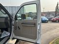 A 2009 Ford F-550 with the driver side door open showcasing the interior handle and panel design