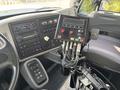 Interior view of a 2013 International WorkStar showing the control panel with buttons gauges and levers alongside the driver's seat and steering wheel
