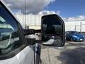 A 2024 Ford F-550 with a side mirror displaying a reflection of the sky and nearby vehicles