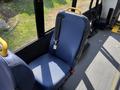 A blue fabric seat with a yellow handle and seatbelt inside a vehicle