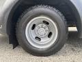 Close-up of a silver wheel and tire from a 2020 Chevrolet Express showcasing the tire tread and five bolt pattern on the rim