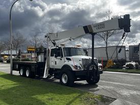 A 2008 International 7500 truck with a National Crane mounted on the back featuring a boom and hook for lifting heavy objects