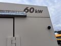 A beige generator with the label 60 kw visible on its side