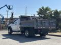 2016 RAM 5500 pickup truck with a flatbed and metallic dump body parked with tools and machinery visible in the bed
