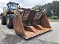 A rusty bucket attachment for a 2012 Caterpillar 980 large wheeled loader with a grid pattern on the front and two scooping sections