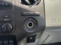 Interior dashboard of a 2015 Ford F-750 showing knobs for climate control and an open 12V power outlet